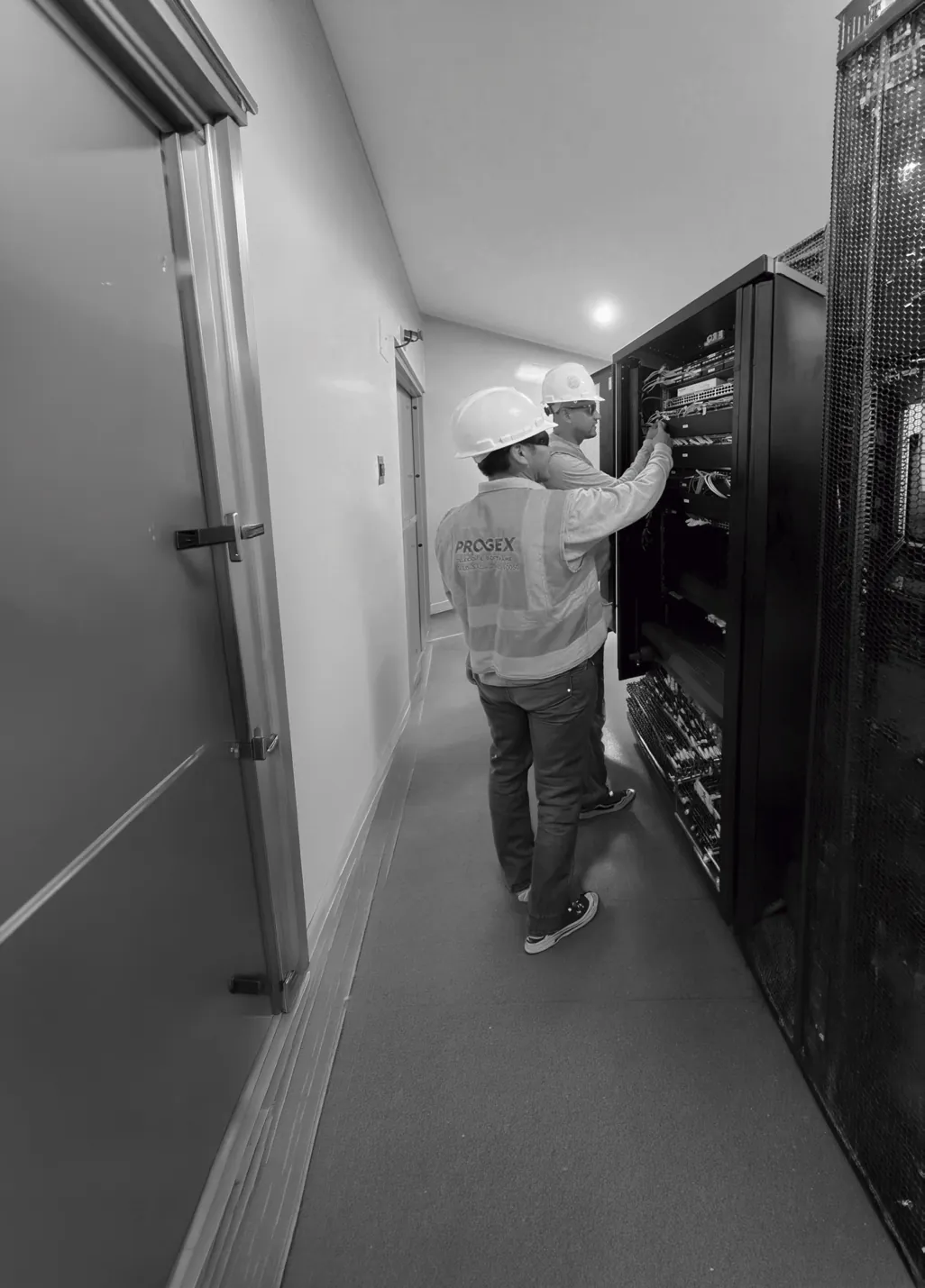 Técnico en el pasillo de una sala de equipos de comunicaciones.