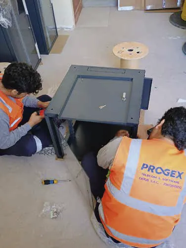 Técnicos de PROGEX instalando un gabinete de servidores.