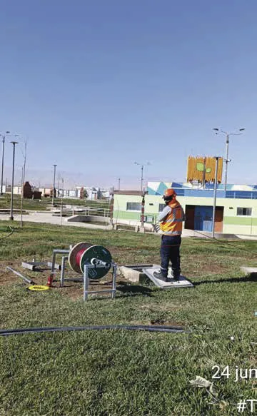 Técnico en campo junto a bobinas de fibra óptica durante un tendido.